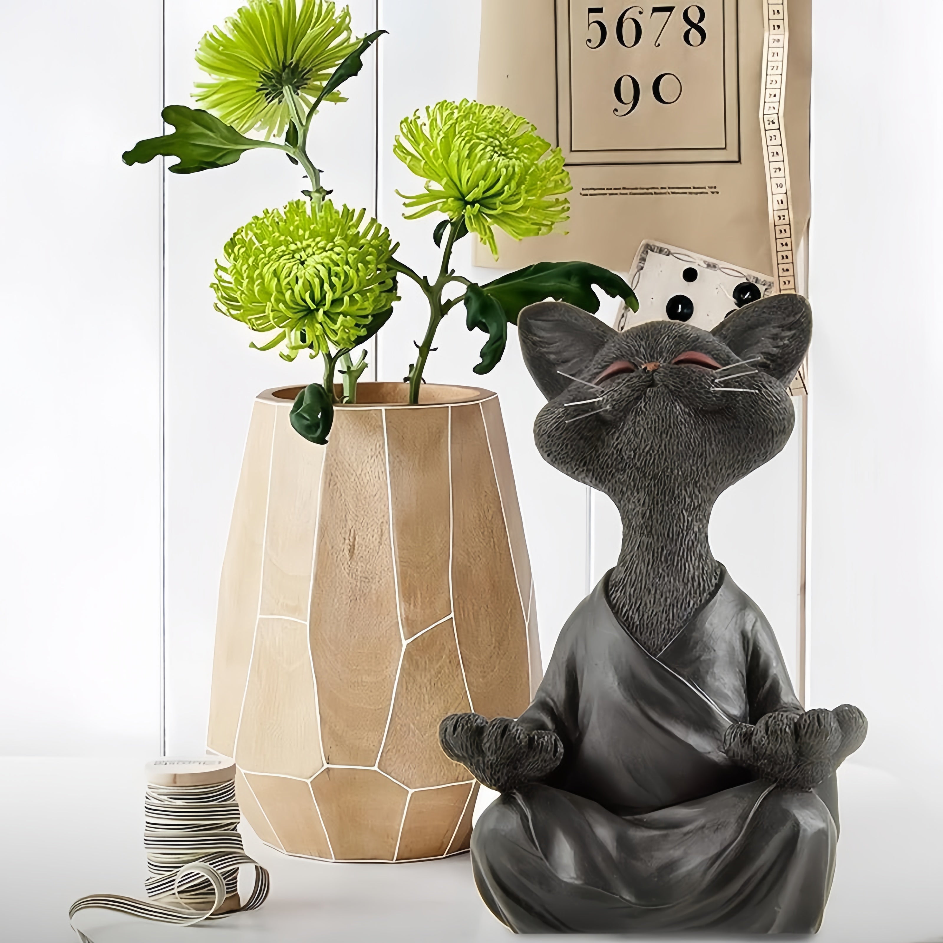 Meditation cat statue beside flowers