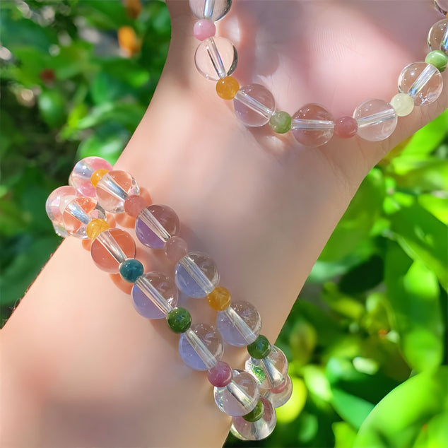 Close-up of a wrist wearing a rainbow tourmaline quartz bracelet in a natural setting, highlighting its beauty.