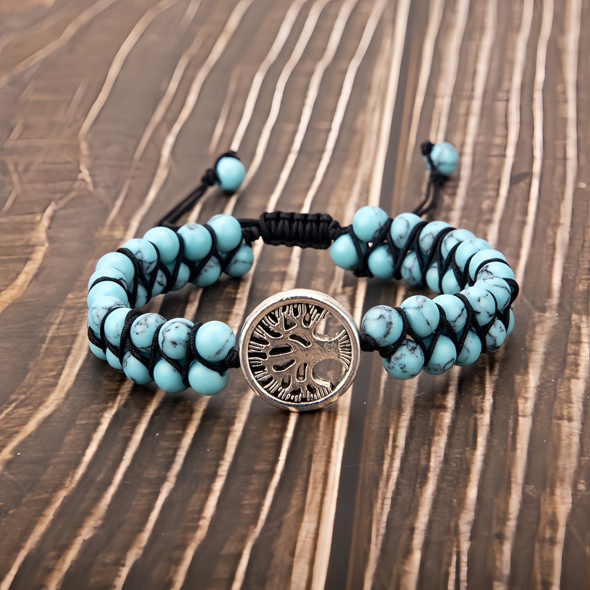 Turquoise yoga bracelet with a central silver tree of life design charm.